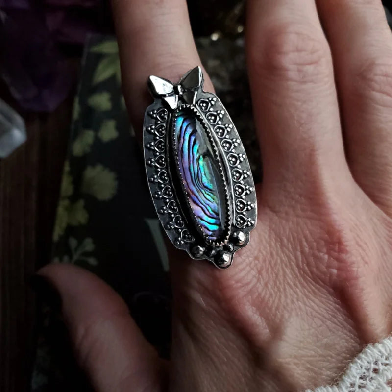 someone is holding a ring with a cat’s paw on it