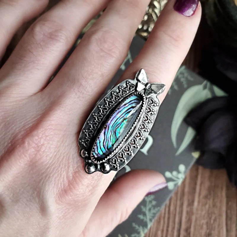 a close up of a person’s hand with a ring on it