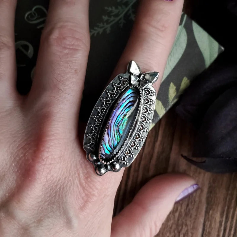 someone is holding a ring with a cat on it