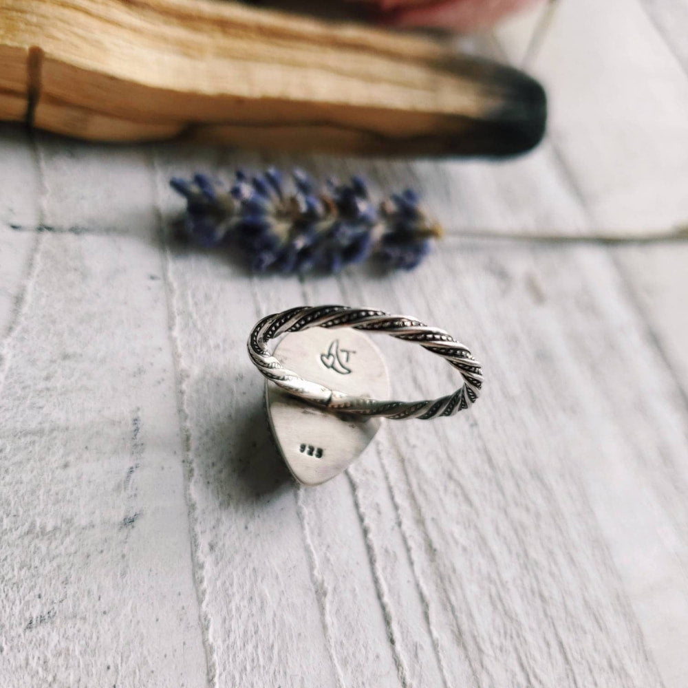 a silver ring with a small initial on it