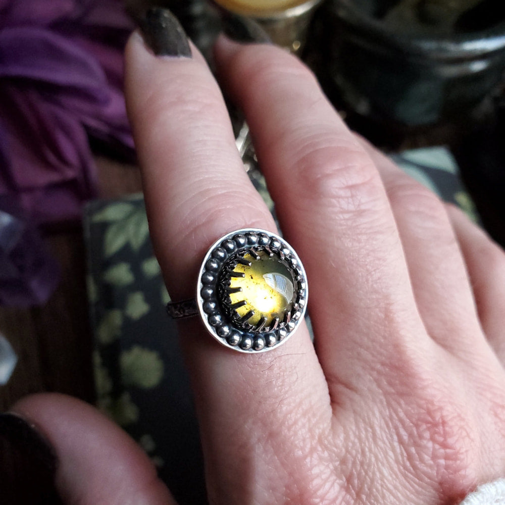 a person wearing a ring with a yellow bird on it