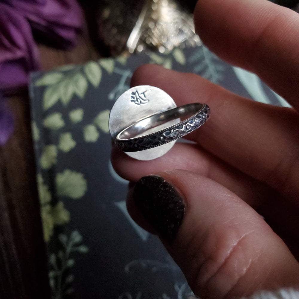 a person holding a ring with a flower design