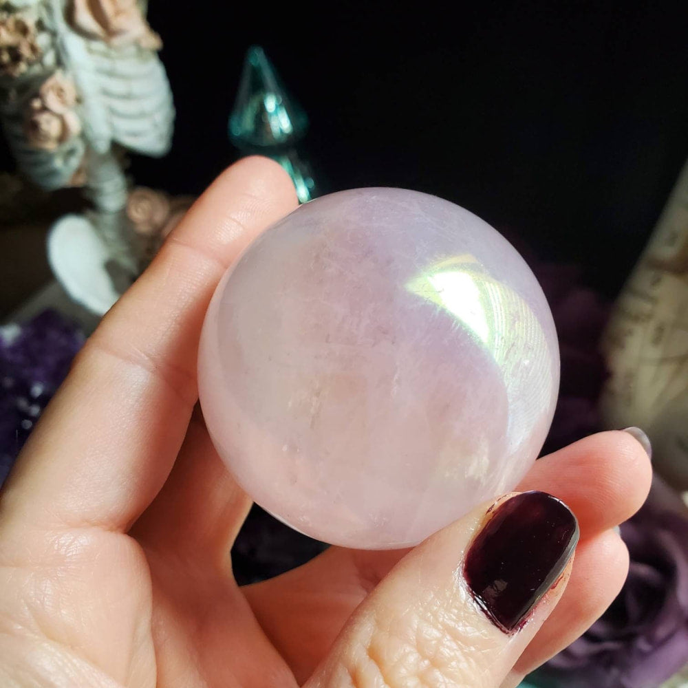 a person holding a large pink quartz ball