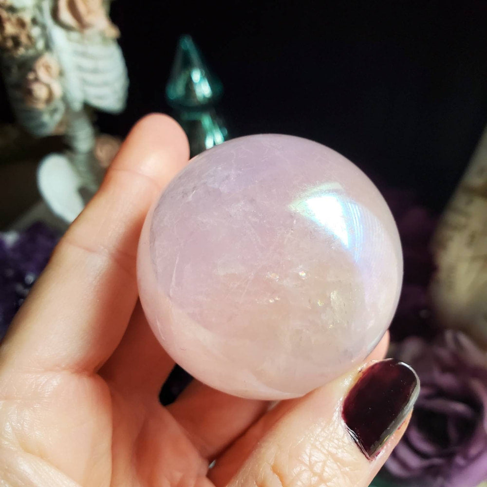 a person holding a pink quartz ball