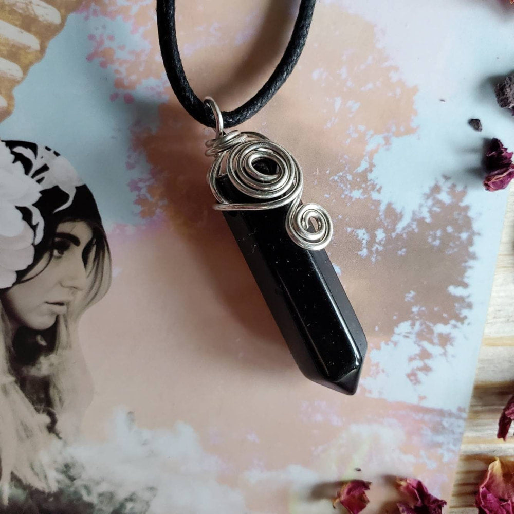 a black stone pendant with a silver wire