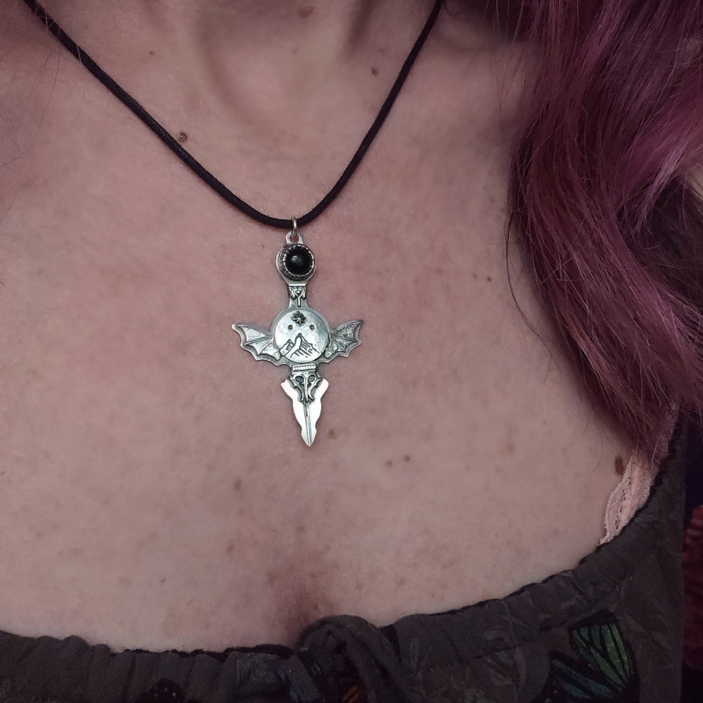 Silver bat-winged pendant necklace.