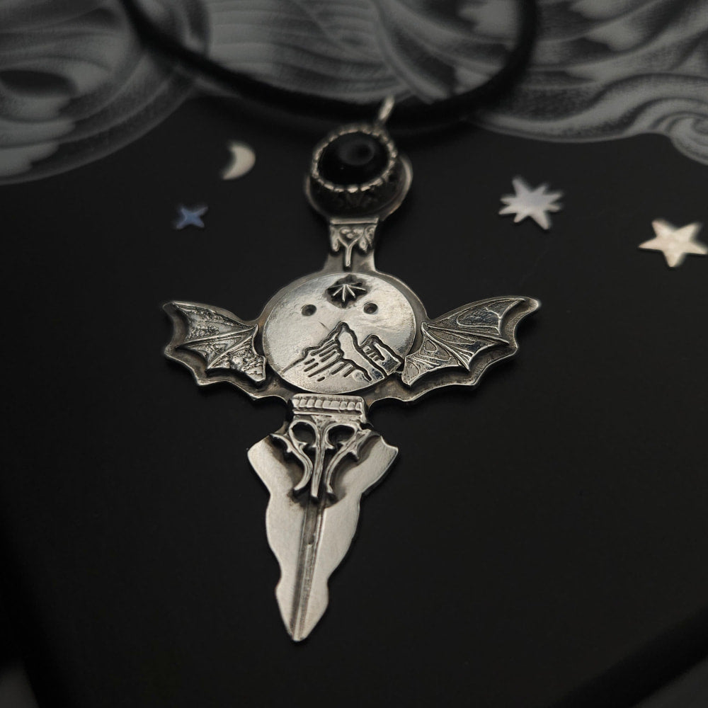 Silver bat-winged dagger pendant.