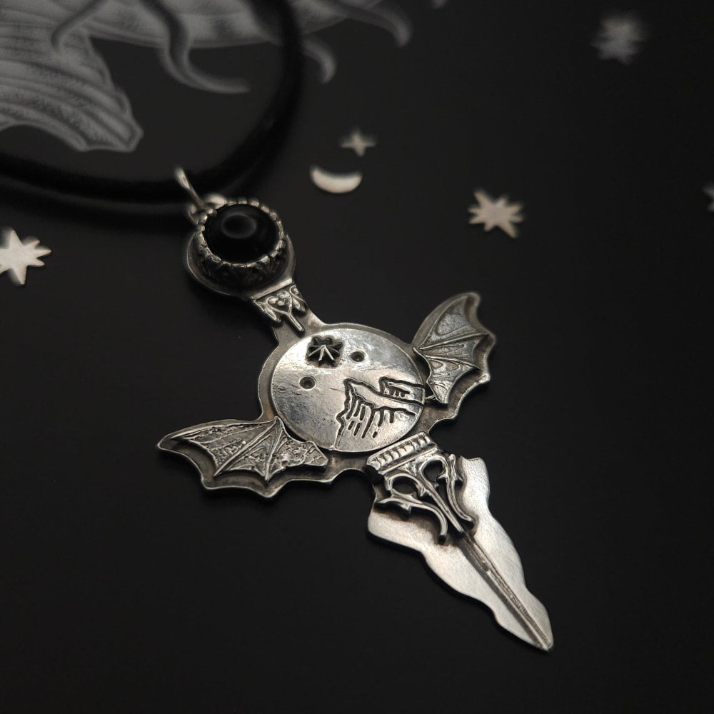 Silver bat-winged cross pendant.