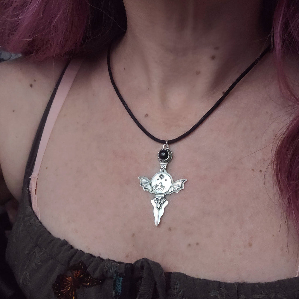 Silver bat-winged pendant necklace.