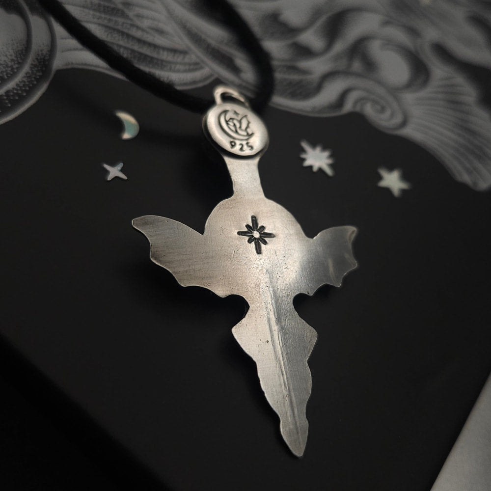Silver bat-winged cross pendant.