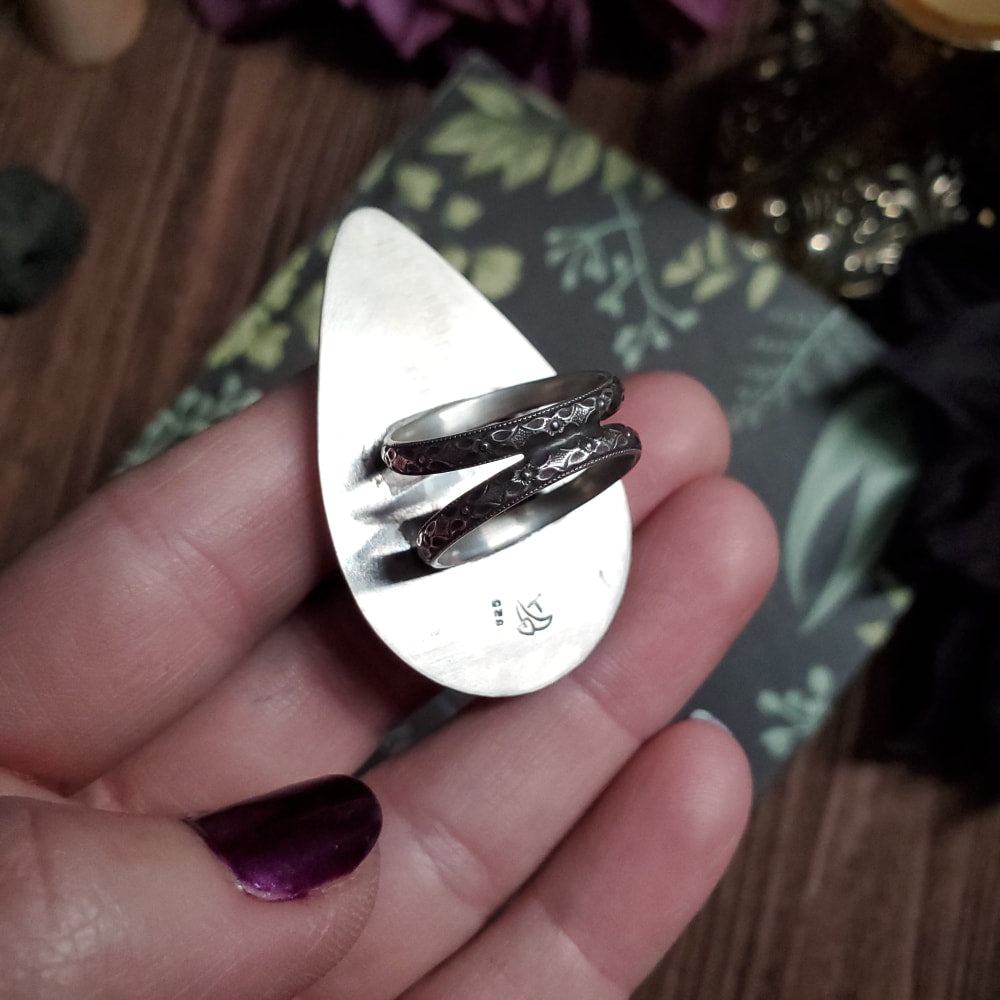 a person holding a silver ring in their hand