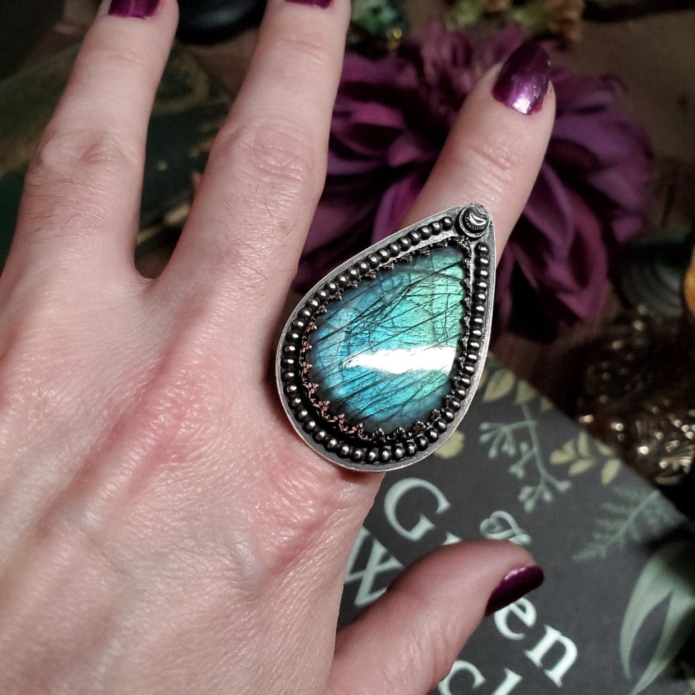 a close up of a person’s hand with a ring on it