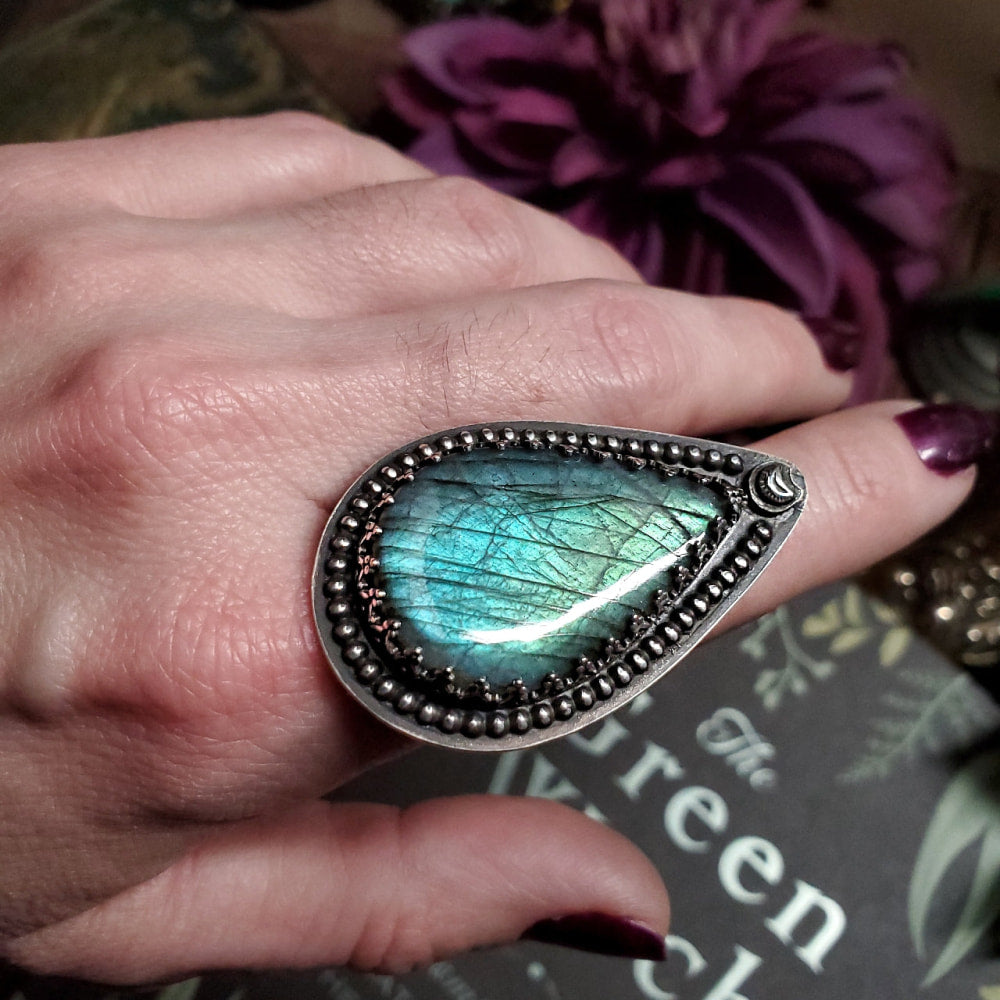 a close up of a person’s hand with a ring on it