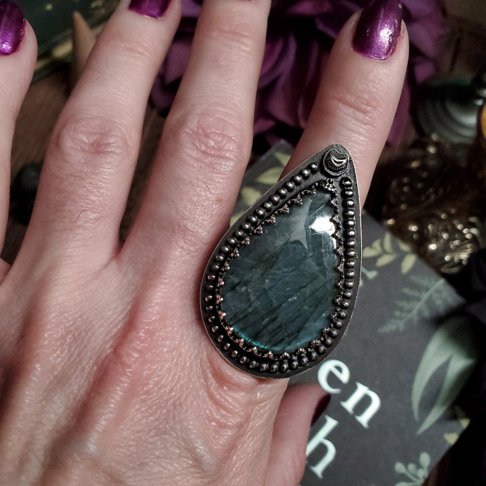 a woman’s hand with a ring on it