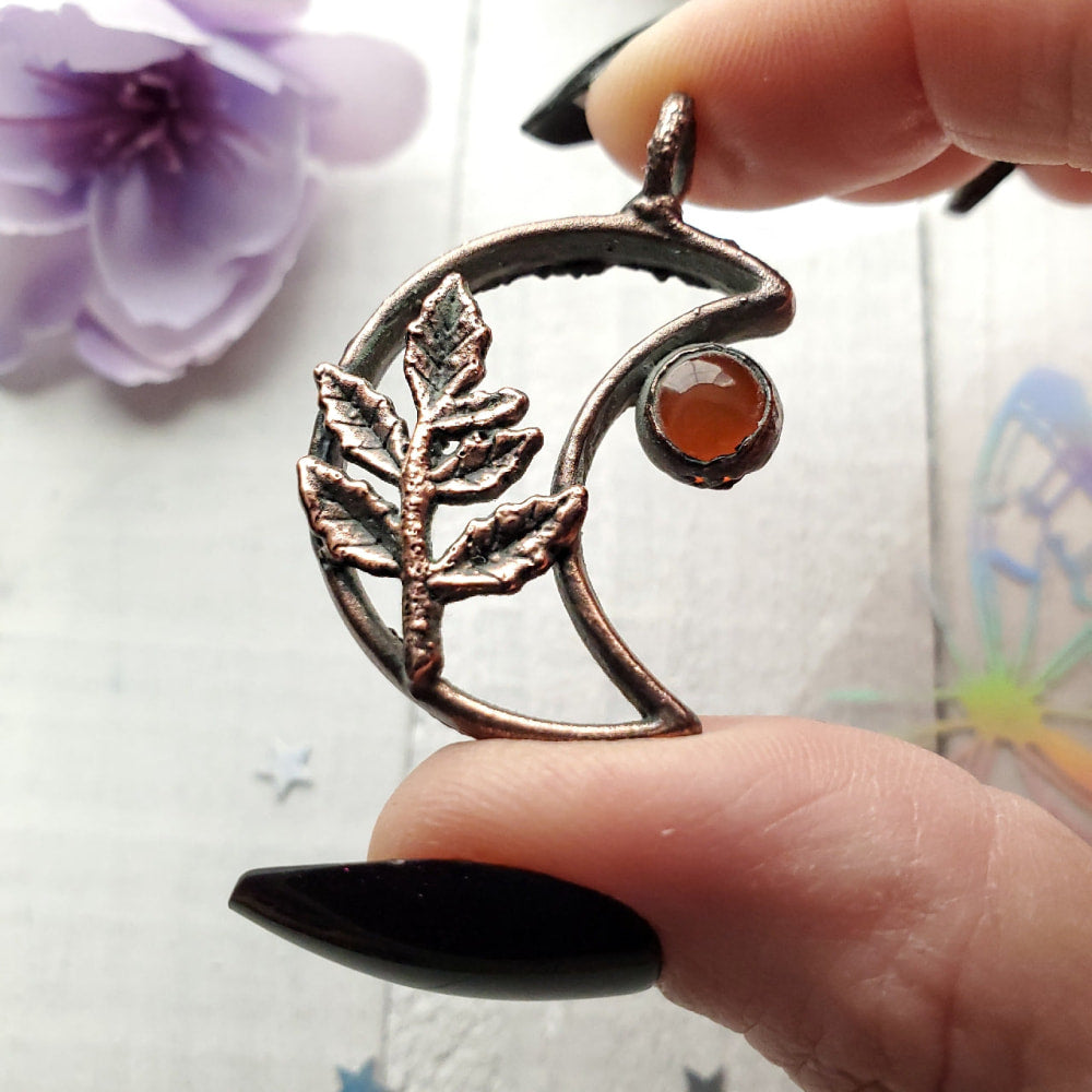 a person holding a silver ring with a flower