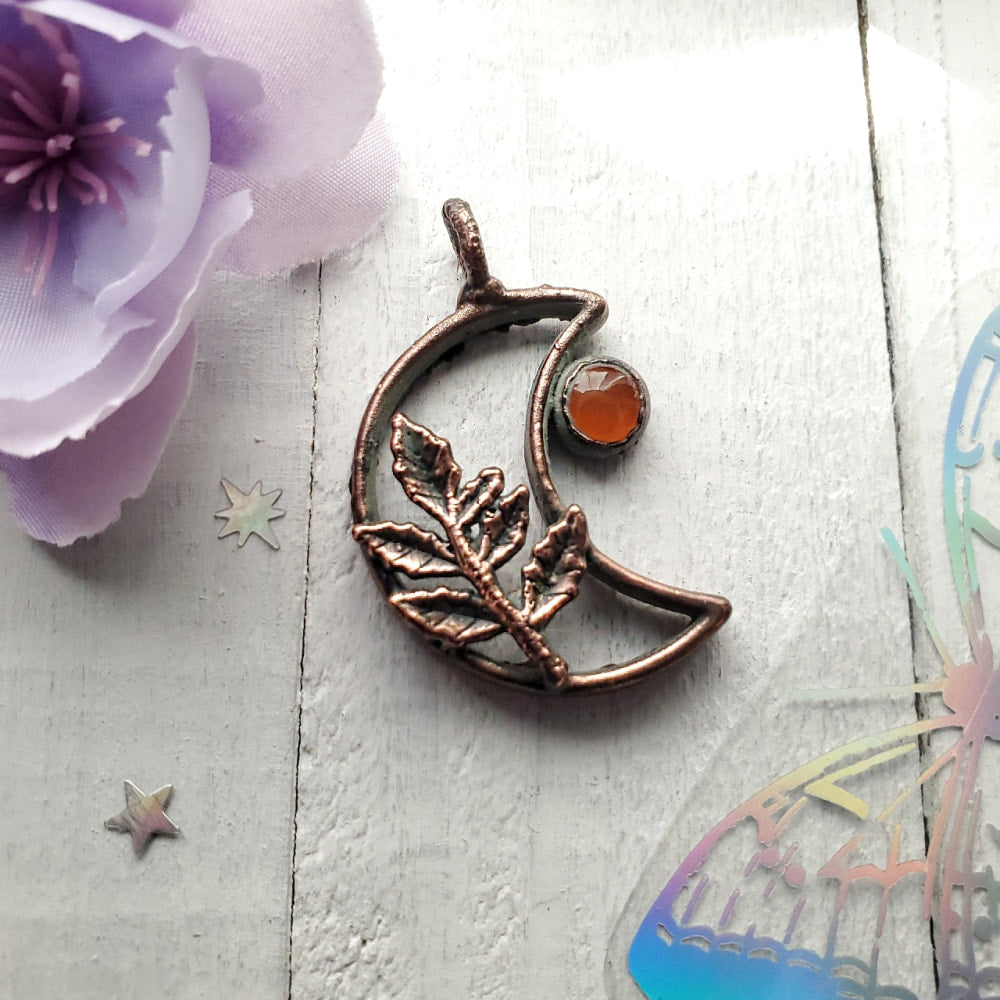 a copper moon with a flower on it