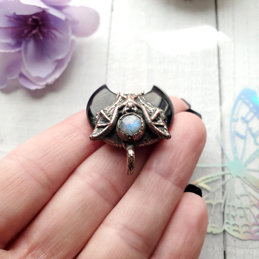 a person holding a ring with a rainbow stone