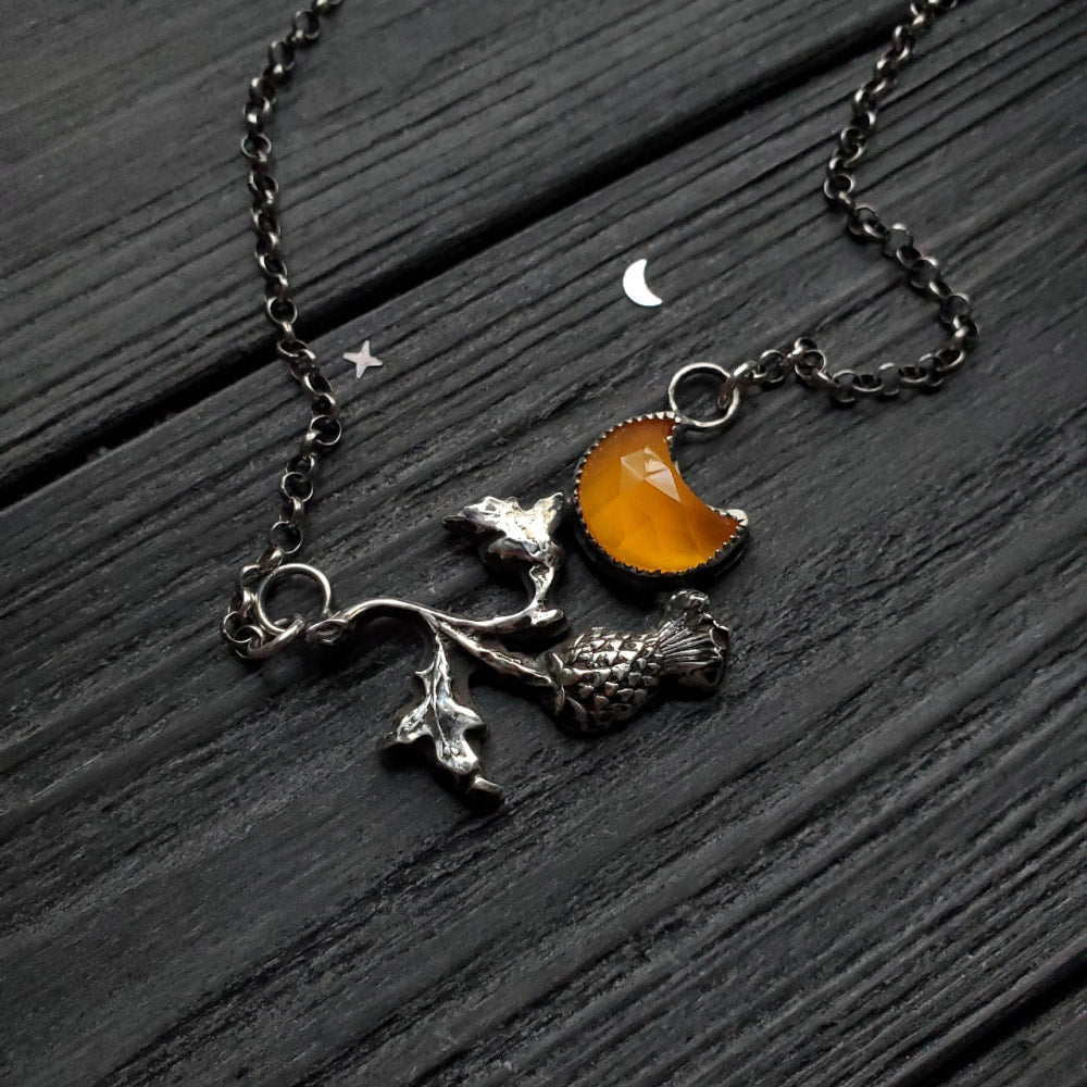 a necklace with a small orange stone on it