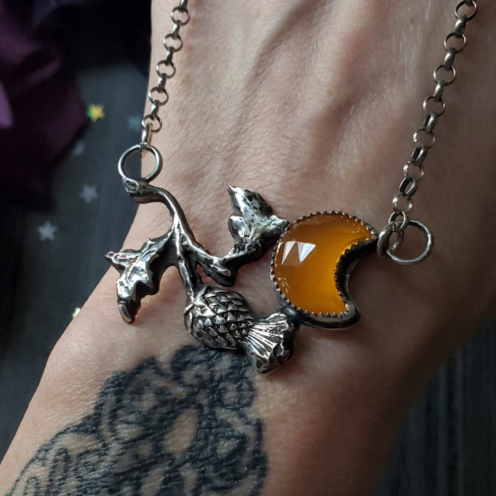 a person with tattoos on their arm holding a yellow glass
