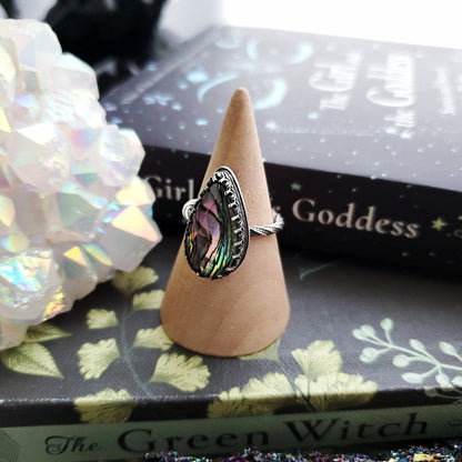 a ring with a green and purple stone in the middle