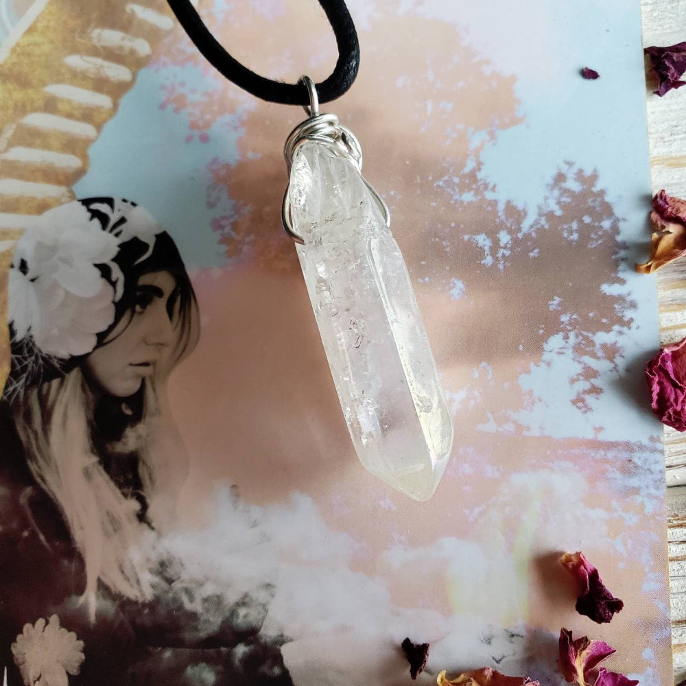 a clear quartz stone pendant on a black cord necklace