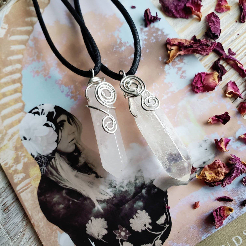 a white quartz stone pendant on a black cord necklace