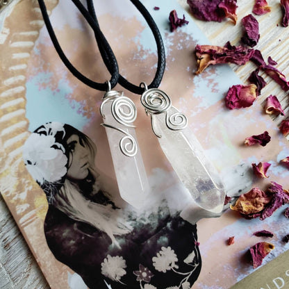 a white quartz stone pendant on a black cord necklace