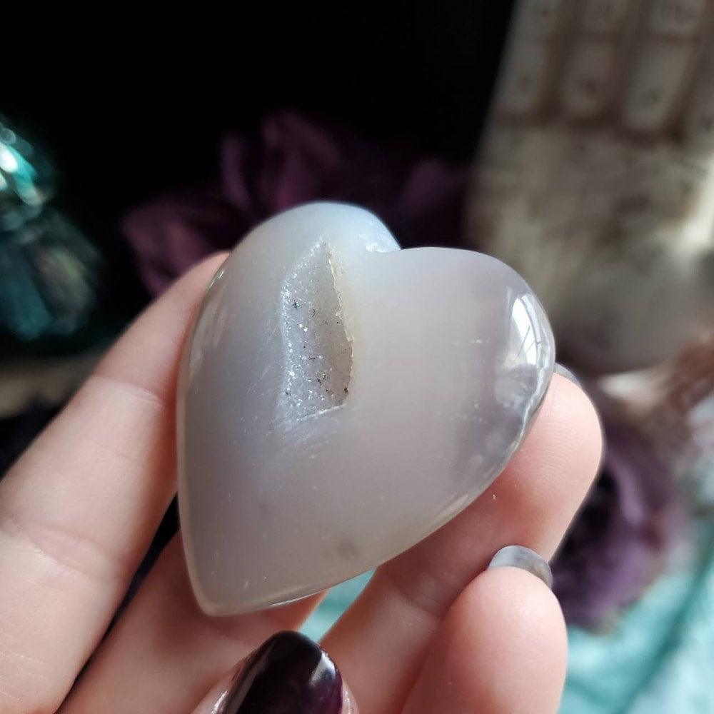 a person holding a white heart shaped rock