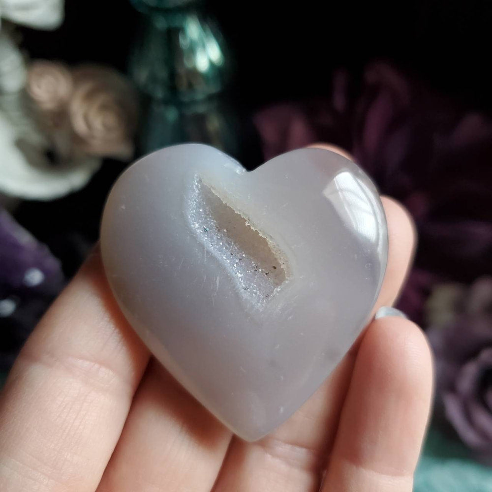 a person holding a white heart shaped rock