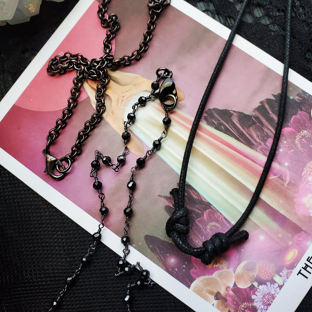 a black necklace with a cross on it