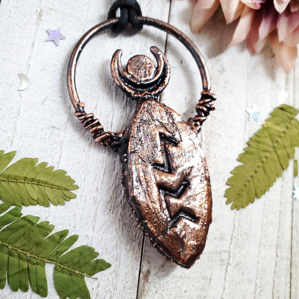 a bronze pendant with a horned head on it