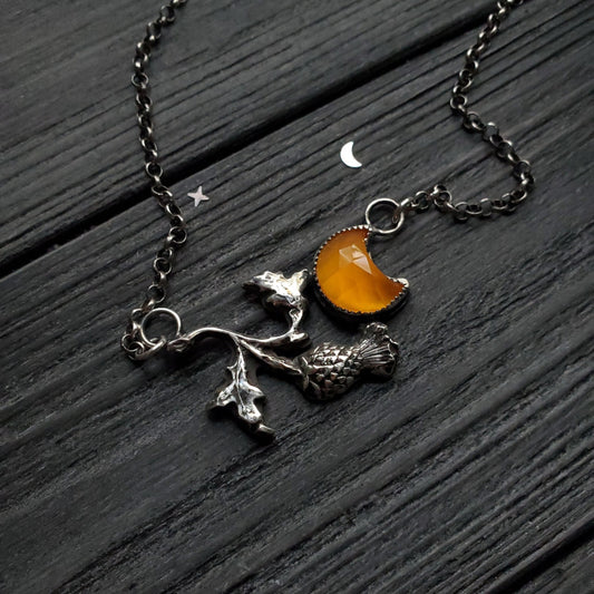 a necklace with a small orange stone on it